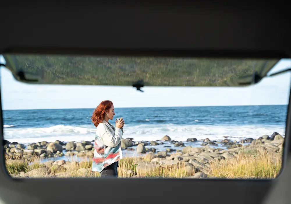 Blick aus dem Wohnwagen von LMC - Natur pur, Frau am Strand